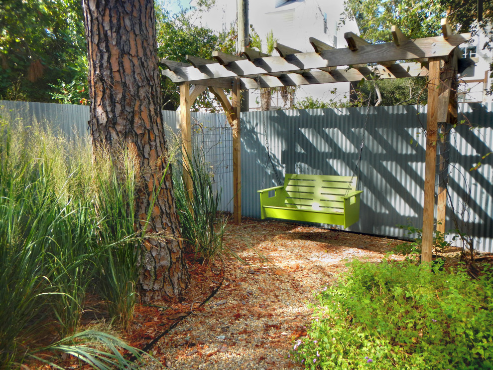 Idee per un giardino design esposto a mezz'ombra di medie dimensioni e dietro casa con uno spazio giochi e ghiaia
