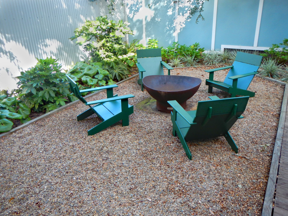 Modelo de jardín contemporáneo de tamaño medio en patio trasero con brasero, exposición reducida al sol y piedra decorativa