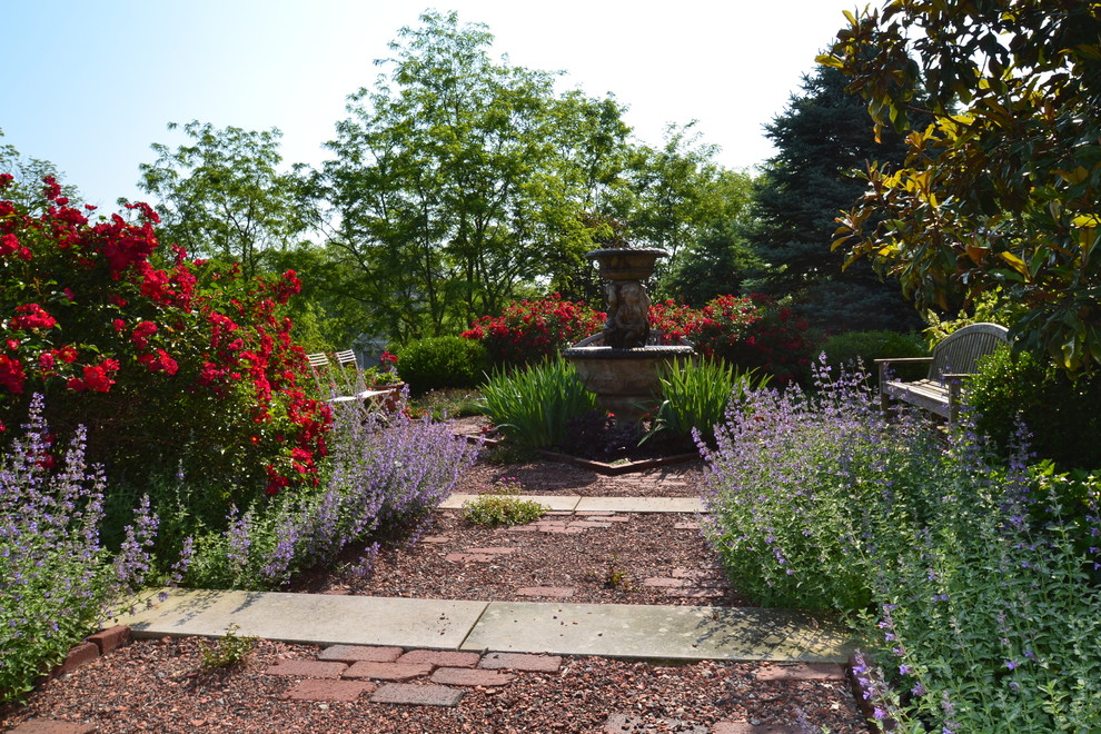 Modelo de jardín clásico en patio trasero con fuente y gravilla