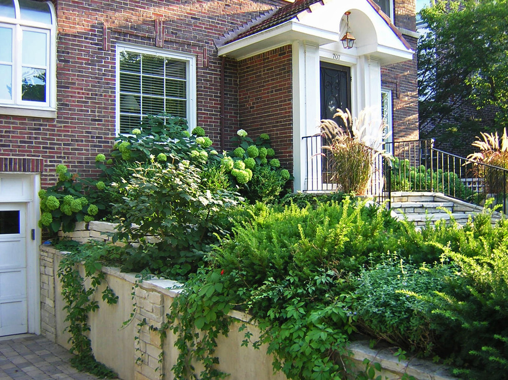 На фото: участок и сад на переднем дворе в классическом стиле с подъездной дорогой и мощением тротуарной плиткой
