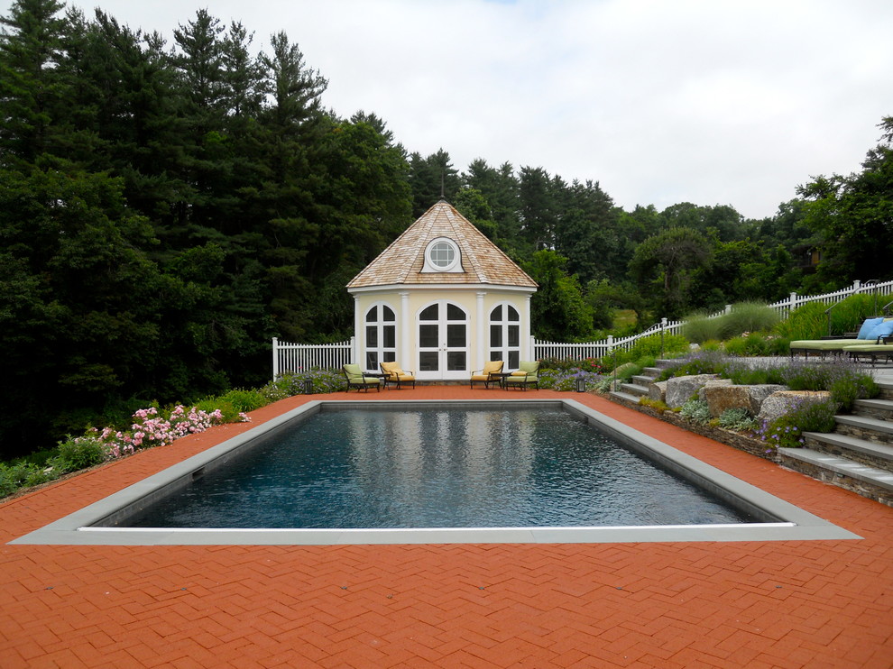 Großer Klassischer Pool hinter dem Haus mit Wasserspiel und Pflastersteinen in New York