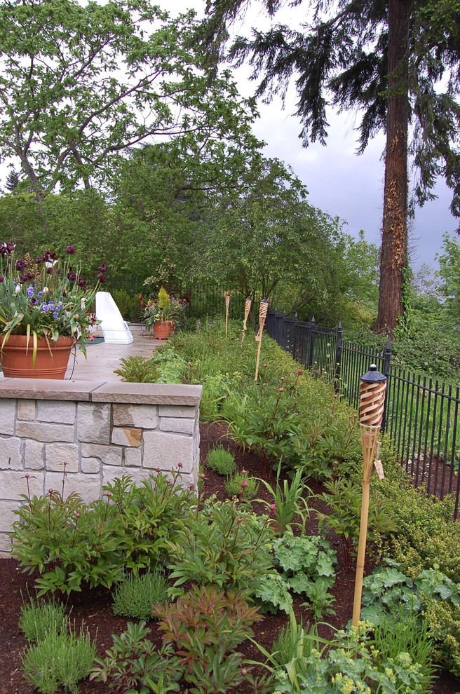 Ispirazione per un ampio giardino classico esposto in pieno sole dietro casa in estate con un muro di contenimento