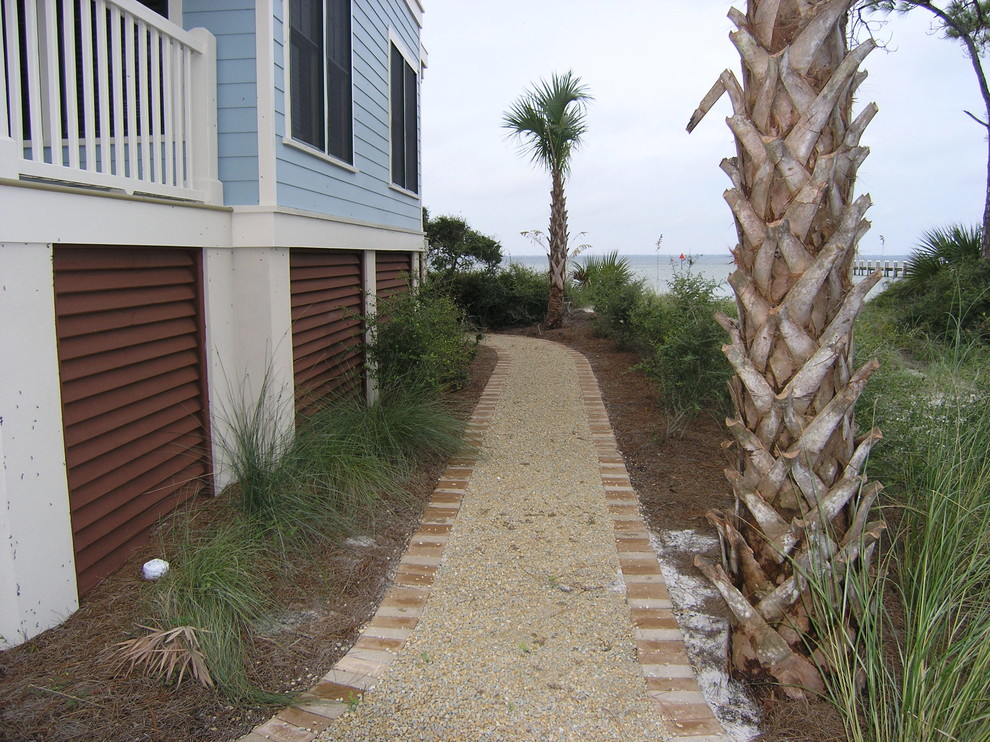 Idee per un vialetto d'ingresso costiero esposto in pieno sole dietro casa in estate con ghiaia