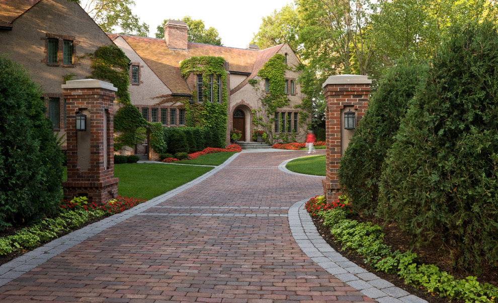 Inspiration for a traditional front driveway garden in Minneapolis with brick paving and lawn edging.