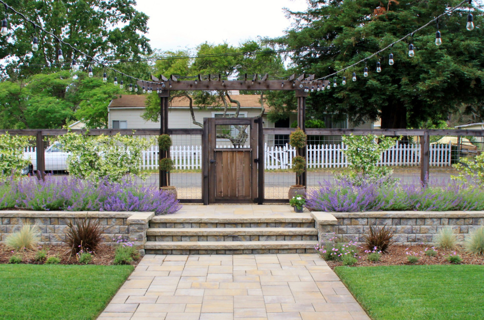 Diseño de jardín de secano de estilo de casa de campo con portón, exposición total al sol, adoquines de hormigón y con metal