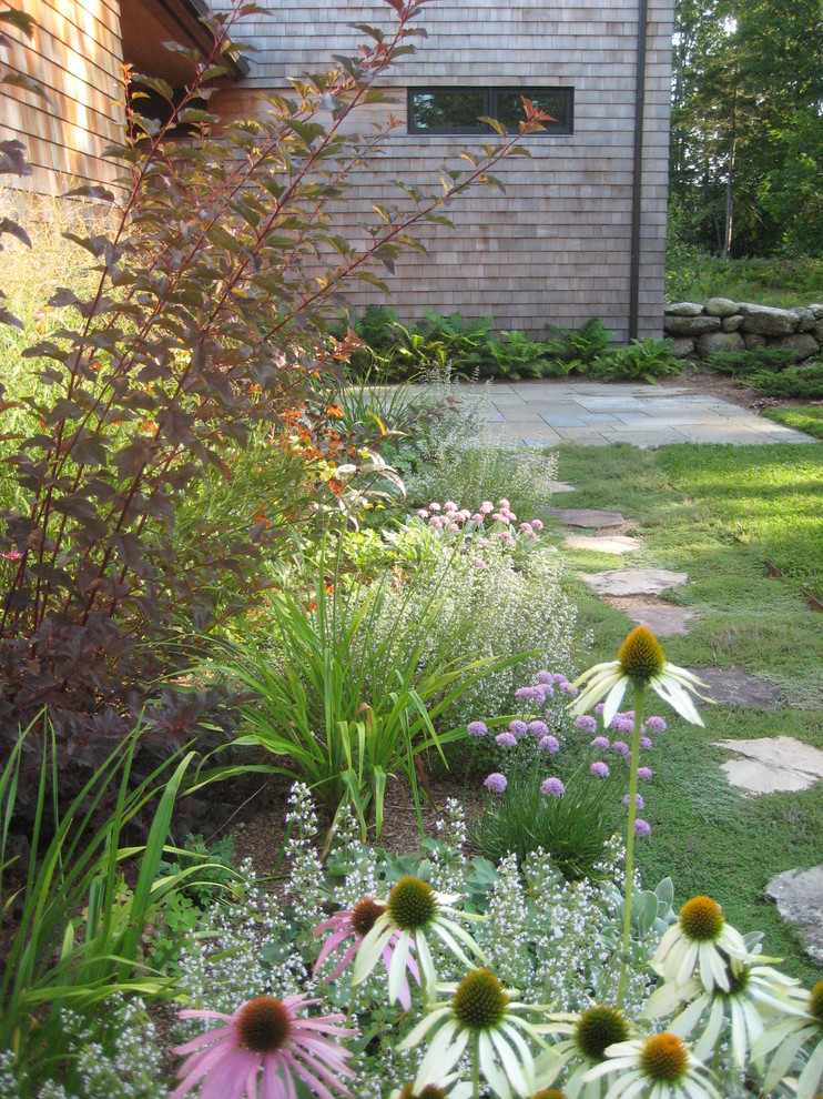 Diseño de jardín clásico de tamaño medio en verano en patio trasero con exposición parcial al sol y adoquines de piedra natural