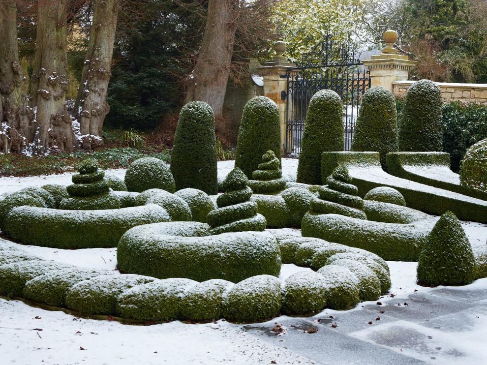 Klassisk inredning av en formell trädgård på vinteren