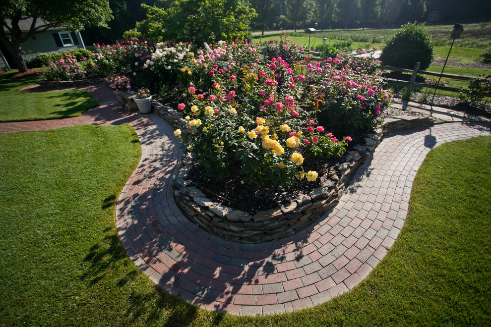 Diseño de jardín romántico grande en patio trasero con jardín francés, exposición total al sol y adoquines de piedra natural