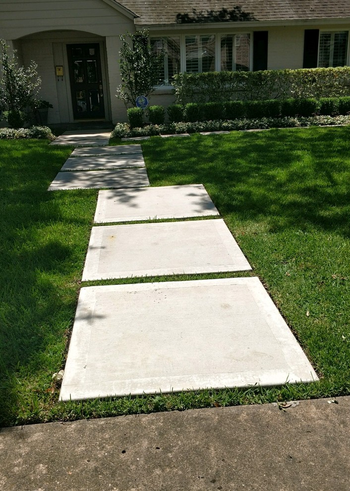 Diseño de jardín actual de tamaño medio en primavera en patio delantero con exposición reducida al sol y adoquines de hormigón