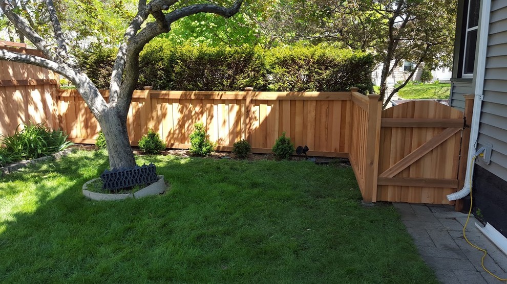Photo of a large traditional partial sun backyard stone landscaping in Minneapolis.