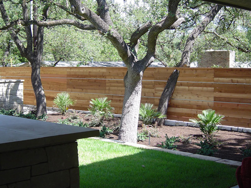Foto de jardín clásico de tamaño medio en primavera en patio trasero con muro de contención y exposición total al sol