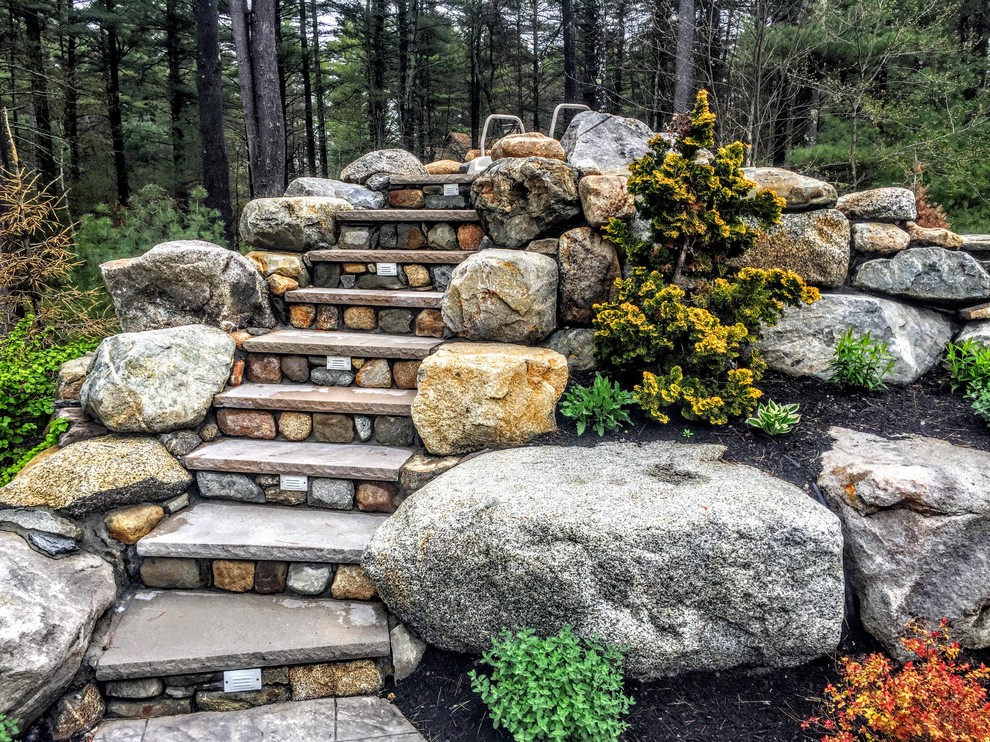 Inspiration for a mid-sized traditional partial sun backyard stone landscaping in Boston.