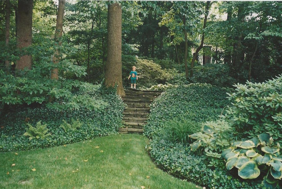 Cette photo montre un très grand jardin arrière chic au printemps avec une exposition partiellement ombragée et des pavés en pierre naturelle.