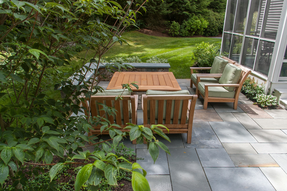 Immagine di un piccolo giardino classico esposto a mezz'ombra dietro casa con un focolare e pavimentazioni in pietra naturale