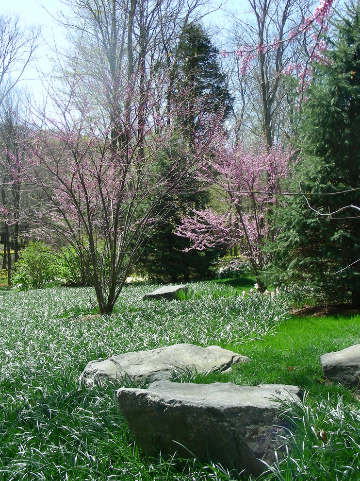 This is an example of a large traditional partial sun backyard formal garden in New York.