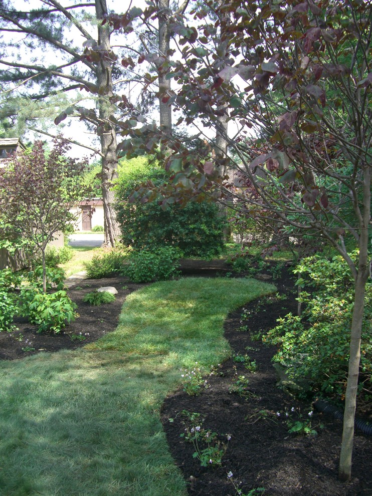 На фото: большой тенистый, весенний участок и сад на заднем дворе в стиле неоклассика (современная классика) с садовой дорожкой или калиткой и мульчированием с