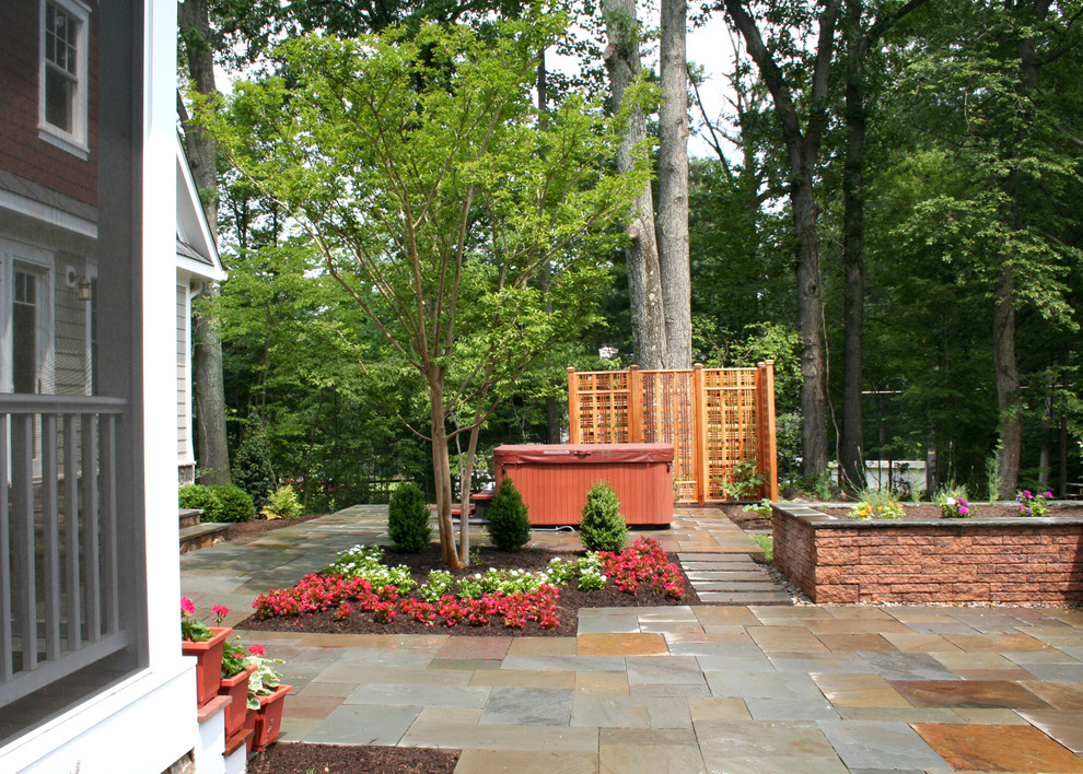 Photo of a mid-sized traditional backyard stone landscaping in DC Metro.