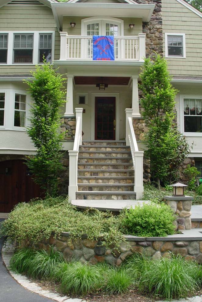 This is an example of a large traditional shade front yard stone driveway in New York.