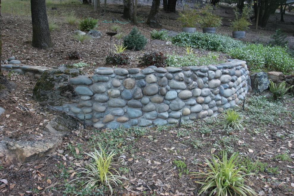 Exempel på en mellanstor klassisk trädgård i skuggan som tål torka och i slänt, med en stödmur