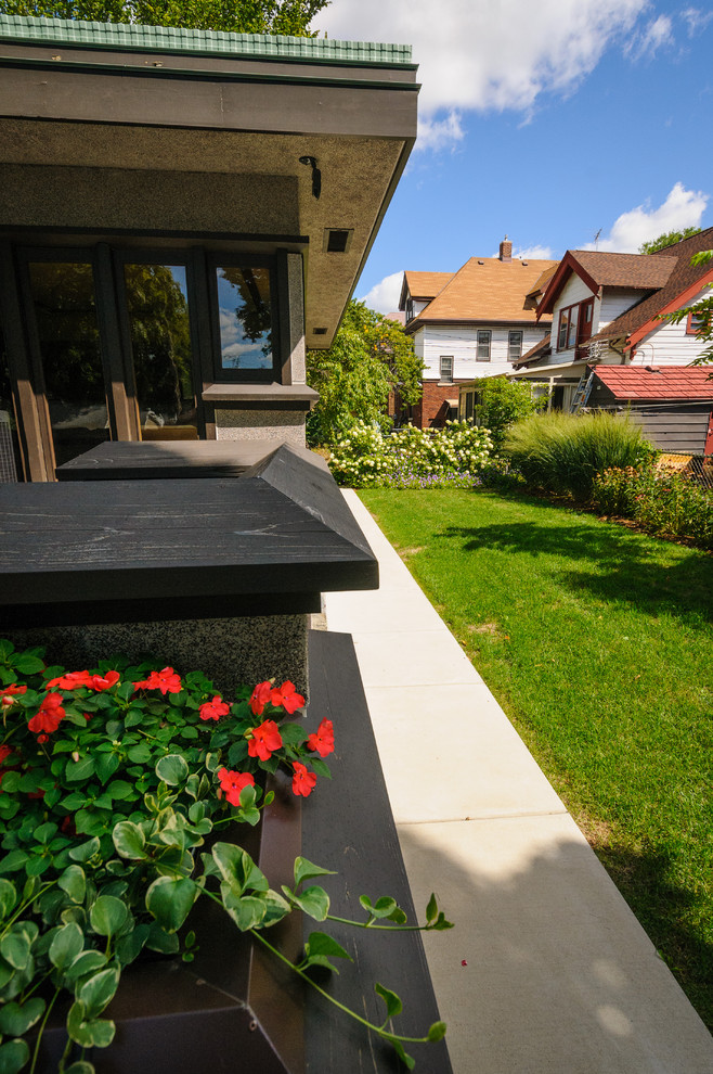 This is an example of a small modern partial sun backyard concrete paver garden path in Milwaukee for summer.