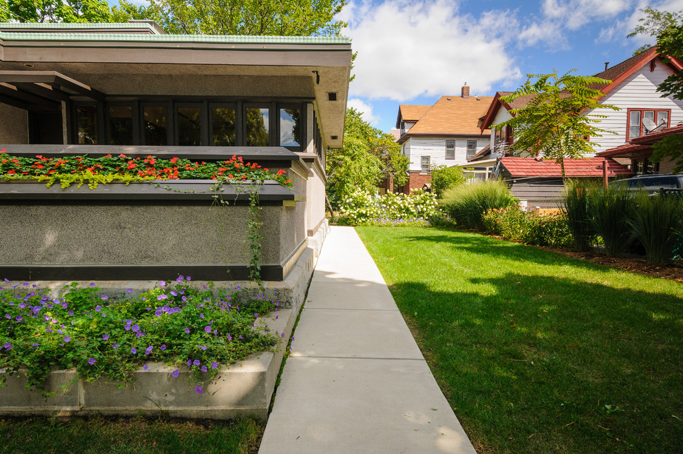 Photo of a small modern partial sun front yard concrete paver garden path in Milwaukee for summer.
