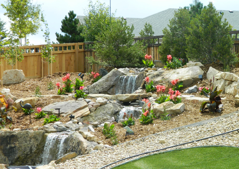 Photo of a mid-sized contemporary drought-tolerant and full sun backyard waterfall in Denver.