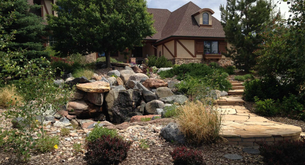 Design ideas for a large contemporary front xeriscape full sun garden in Denver with a waterfall and natural stone paving.
