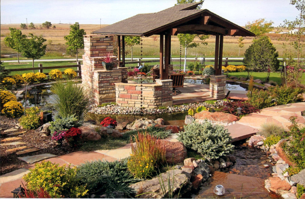 Idee per un grande giardino xeriscape contemporaneo esposto in pieno sole davanti casa con un caminetto e pavimentazioni in pietra naturale