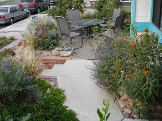 Idee per un piccolo giardino xeriscape stile marino esposto in pieno sole davanti casa in estate con un ingresso o sentiero e ghiaia