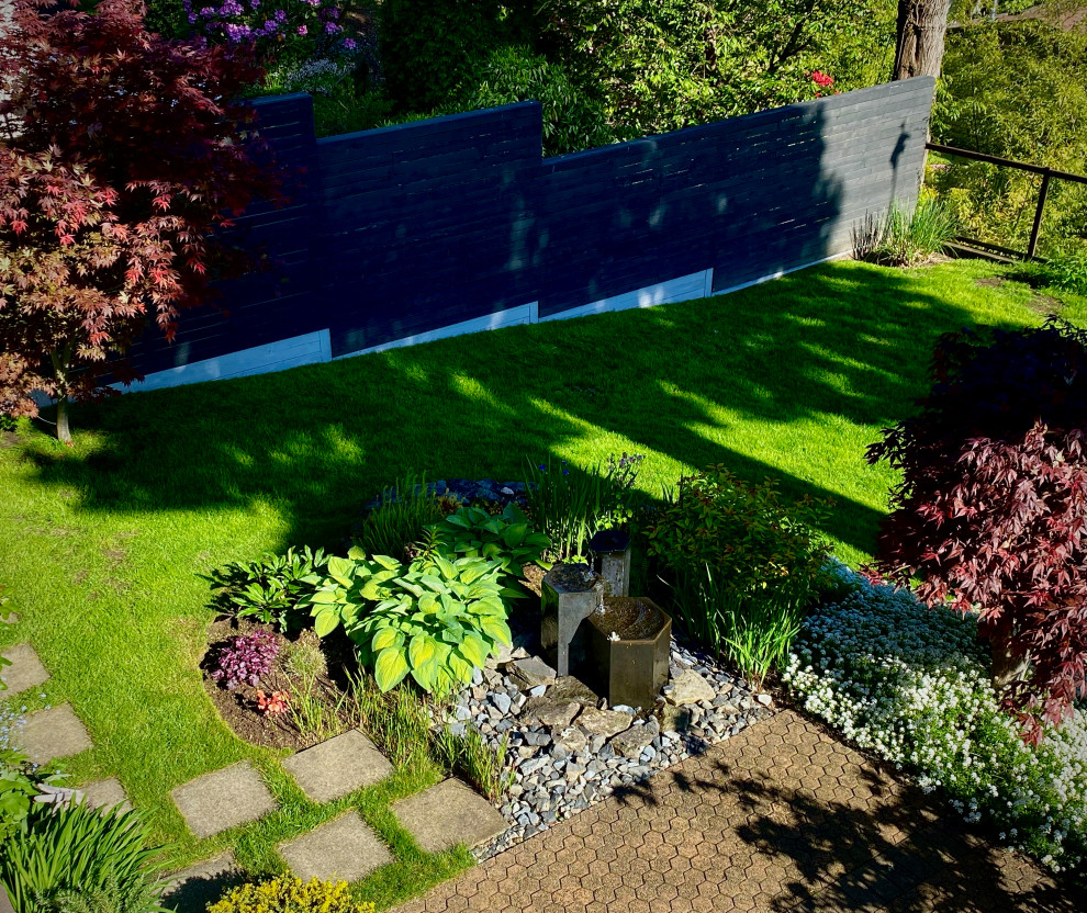 Ispirazione per un giardino stile rurale esposto a mezz'ombra dietro casa con fontane, pavimentazioni in cemento e recinzione in legno
