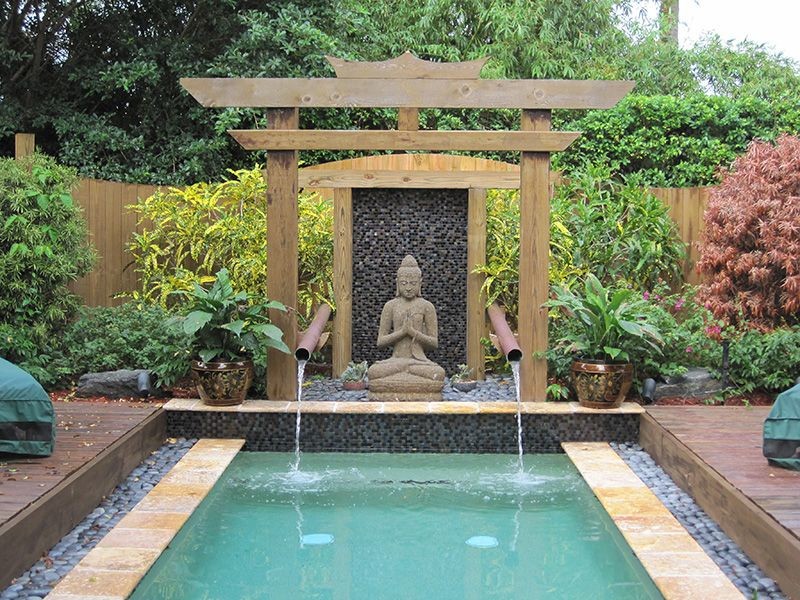 Идея дизайна: садовый фонтан среднего размера на заднем дворе в восточном стиле с настилом