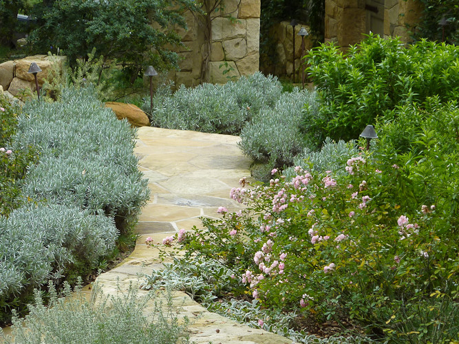 Modelo de camino de jardín mediterráneo en verano con exposición total al sol y adoquines de piedra natural
