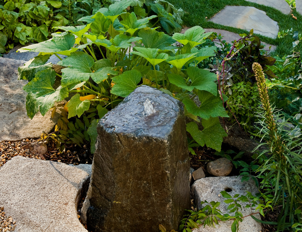 Ejemplo de jardín actual de tamaño medio en verano en ladera con fuente, exposición total al sol y adoquines de piedra natural