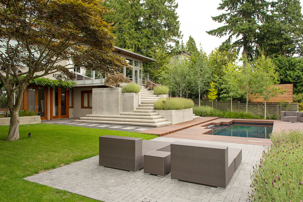 Diseño de jardín retro de tamaño medio en patio trasero con fuente y adoquines de piedra natural