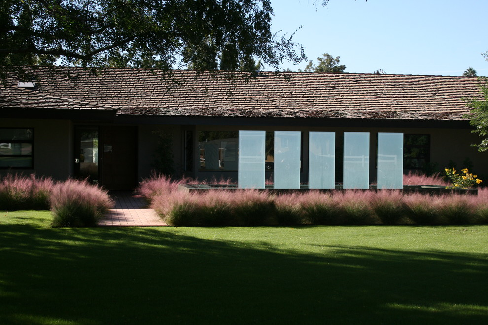 Пример оригинального дизайна: участок и сад среднего размера на переднем дворе в современном стиле с подпорной стенкой, полуденной тенью и мощением тротуарной плиткой