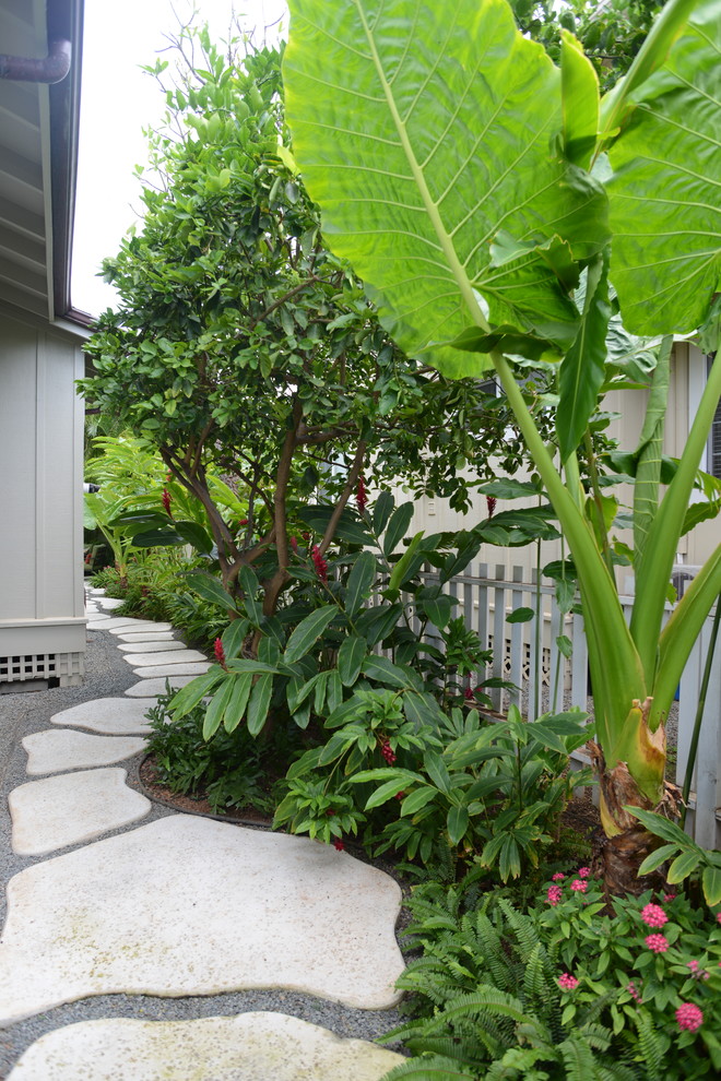 This is an example of a medium sized world-inspired side partial sun garden for summer in Hawaii with concrete paving and a garden path.