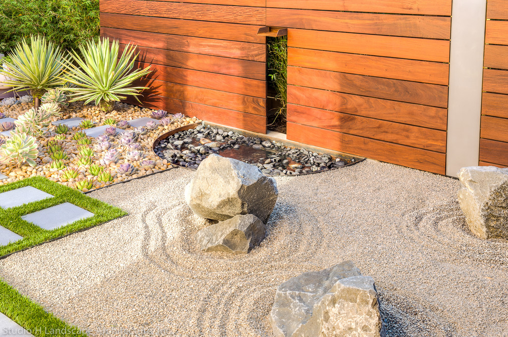 This is an example of a small contemporary backyard gravel water fountain landscape in Orange County.