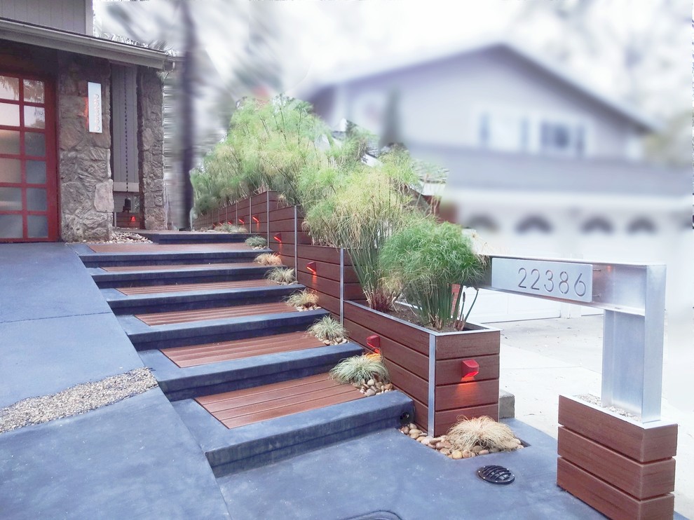 Medium sized world-inspired front driveway full sun garden in Orange County with a garden path and decking.