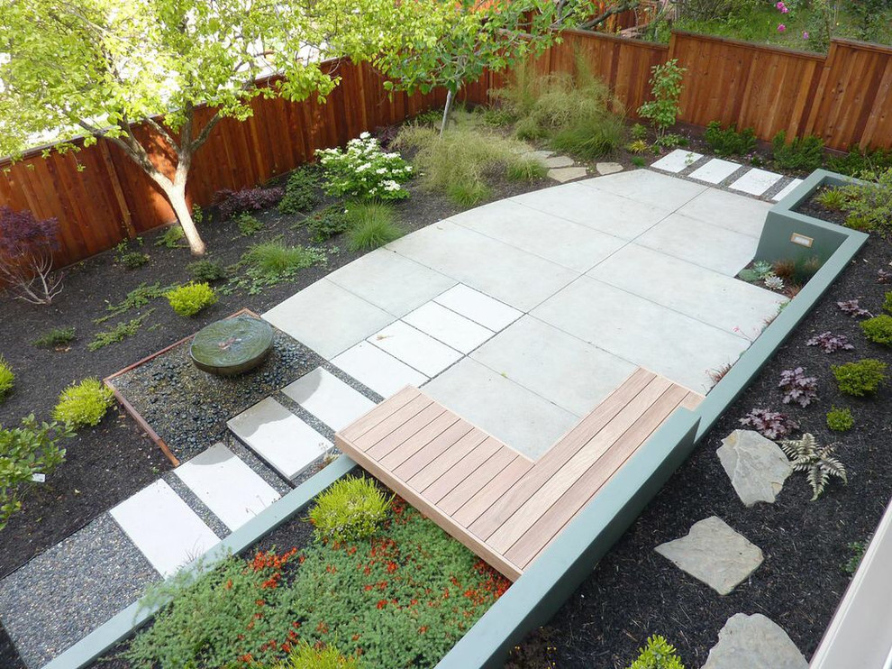 This is an example of a medium sized contemporary back partial sun garden in San Francisco with a water feature and concrete paving.