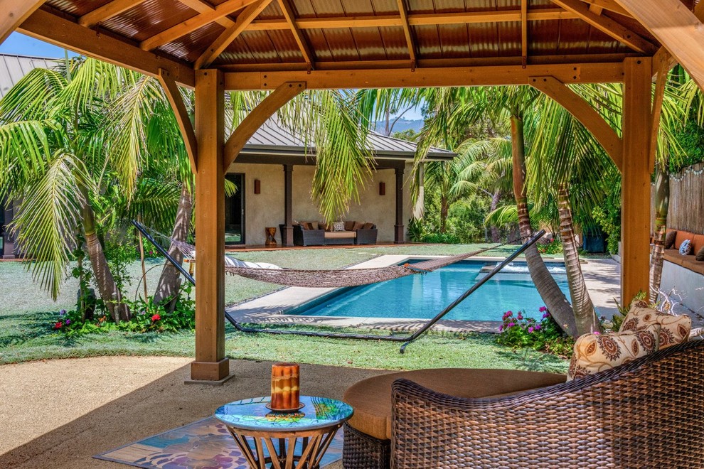 Foto di un giardino tropicale esposto in pieno sole di medie dimensioni e nel cortile laterale in estate con fontane