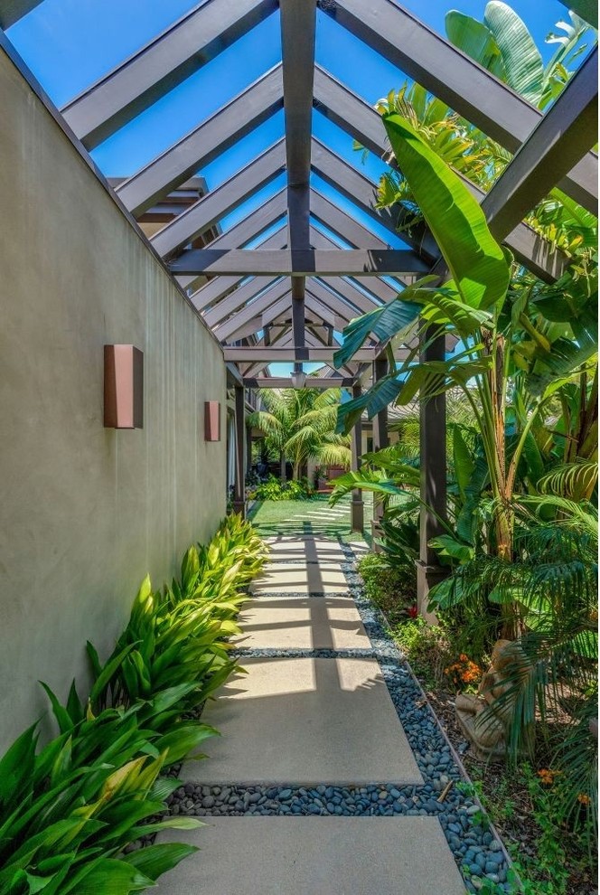 Immagine di un giardino tropicale esposto in pieno sole di medie dimensioni e nel cortile laterale in estate con fontane