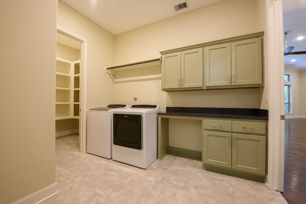 Foto di una sala lavanderia chic di medie dimensioni con ante in stile shaker, ante verdi, top in granito, pareti beige, pavimento in gres porcellanato, lavatrice e asciugatrice affiancate e top nero