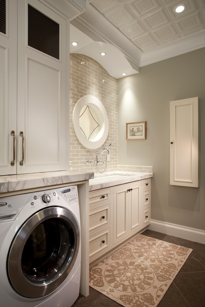 Inspiration för mellanstora klassiska grått tvättstugor enbart för tvätt, med en undermonterad diskho, vita skåp, marmorbänkskiva, en tvättmaskin och torktumlare bredvid varandra och grå väggar