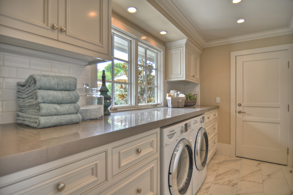 Nautical utility room in Los Angeles with white cabinets, white floors and grey worktops.