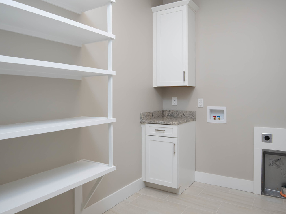 Photo of a medium sized classic l-shaped utility room in Other with shaker cabinets, white cabinets, granite worktops, grey walls, ceramic flooring, a side by side washer and dryer, beige floors and grey worktops.