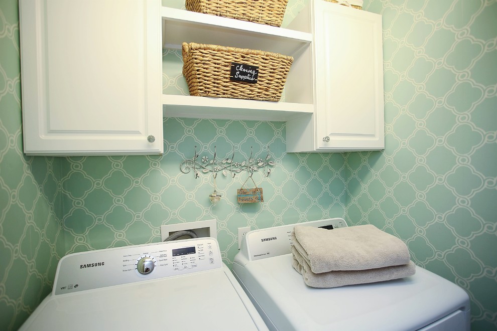 Foto di una lavanderia moderna con pareti verdi e lavatrice e asciugatrice affiancate