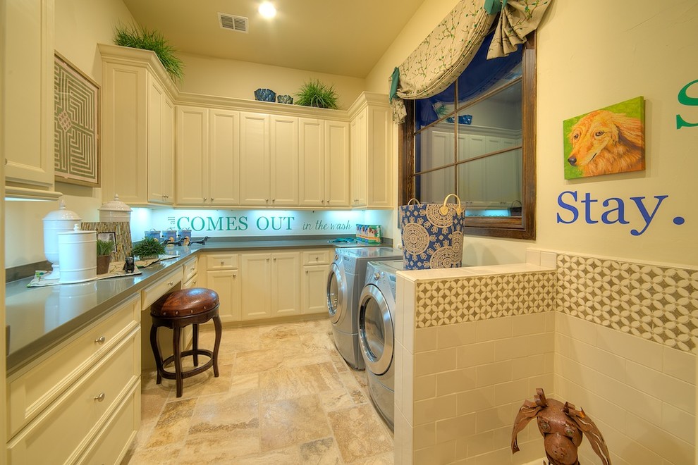 Immagine di una grande sala lavanderia tradizionale con ante con riquadro incassato, ante bianche, pareti beige, pavimento in gres porcellanato, lavatrice e asciugatrice affiancate e pavimento beige
