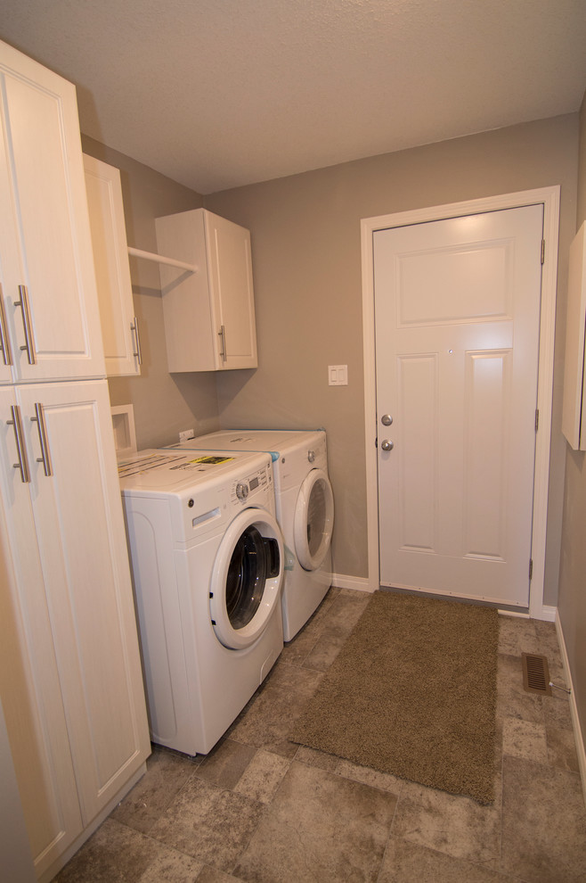 Immagine di una lavanderia multiuso minimal di medie dimensioni con ante con bugna sagomata, ante bianche, pareti beige, pavimento in linoleum e lavatrice e asciugatrice affiancate