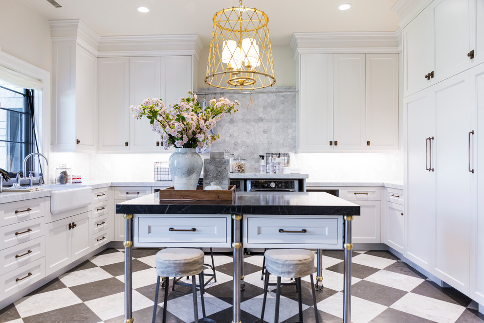 Inspiration for a large timeless u-shaped marble floor and multicolored floor laundry room remodel in Salt Lake City with a farmhouse sink, shaker cabinets, white cabinets, gray backsplash, beige walls, marble countertops, a side-by-side washer/dryer and black countertops