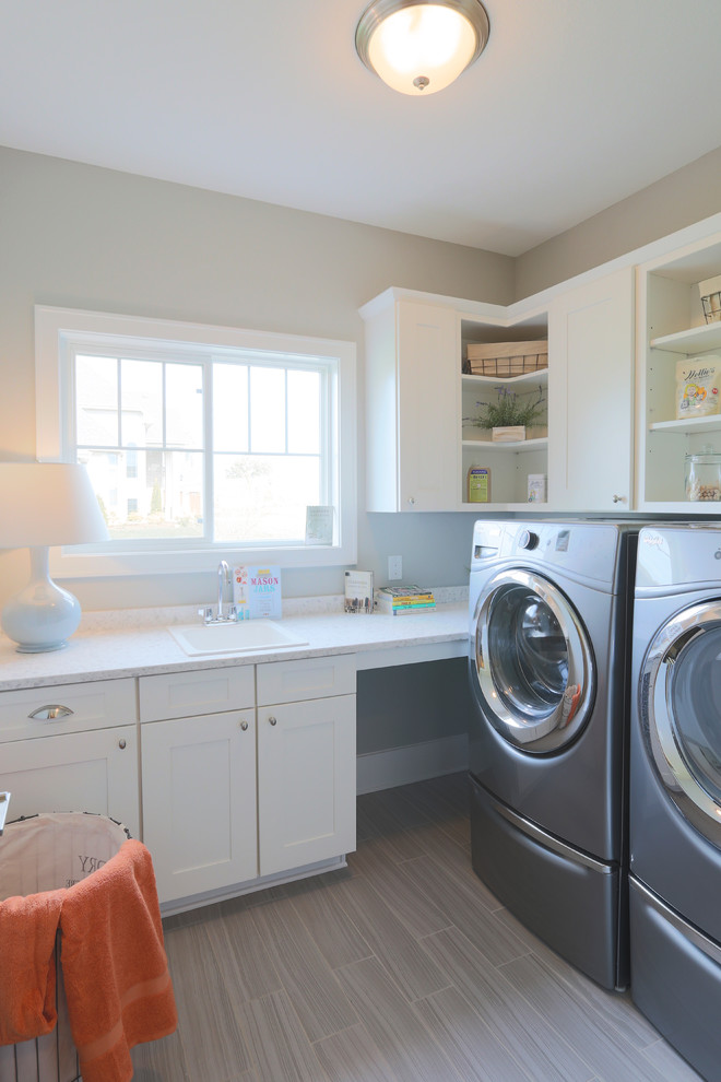 Ejemplo de cuarto de lavado en L de estilo americano de tamaño medio con armarios estilo shaker y puertas de armario blancas
